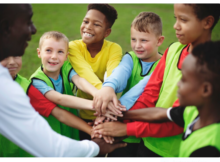 Junior football team stacking hands before a match