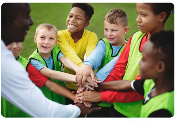 Junior football team stacking hands before a match